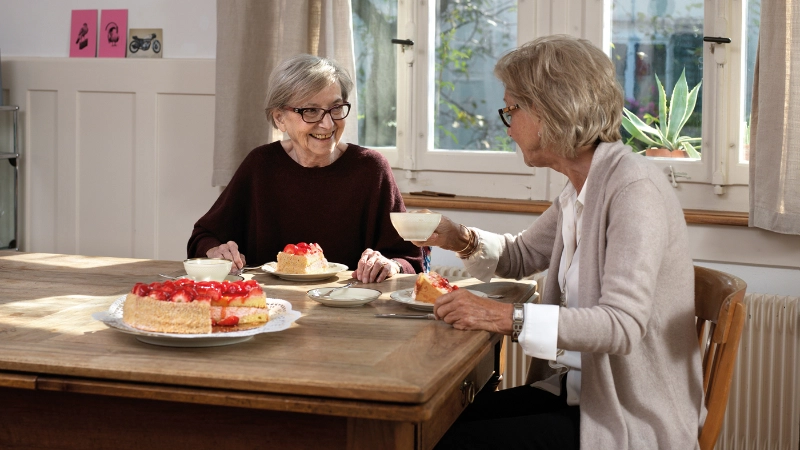 deux dames âgées mangent un gâteau à table