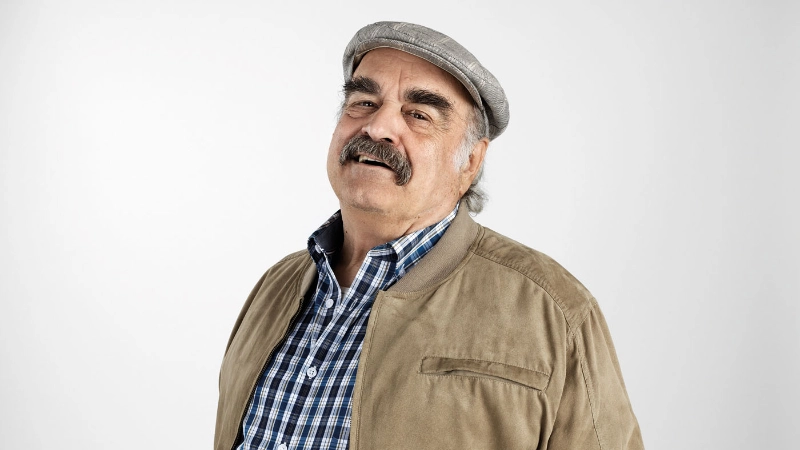 Un homme âgé, moustachu avec une casquette