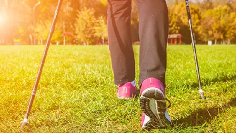 bas des jambes, pieds et bâtons d'une personnes pratiquant le nordic walking 
