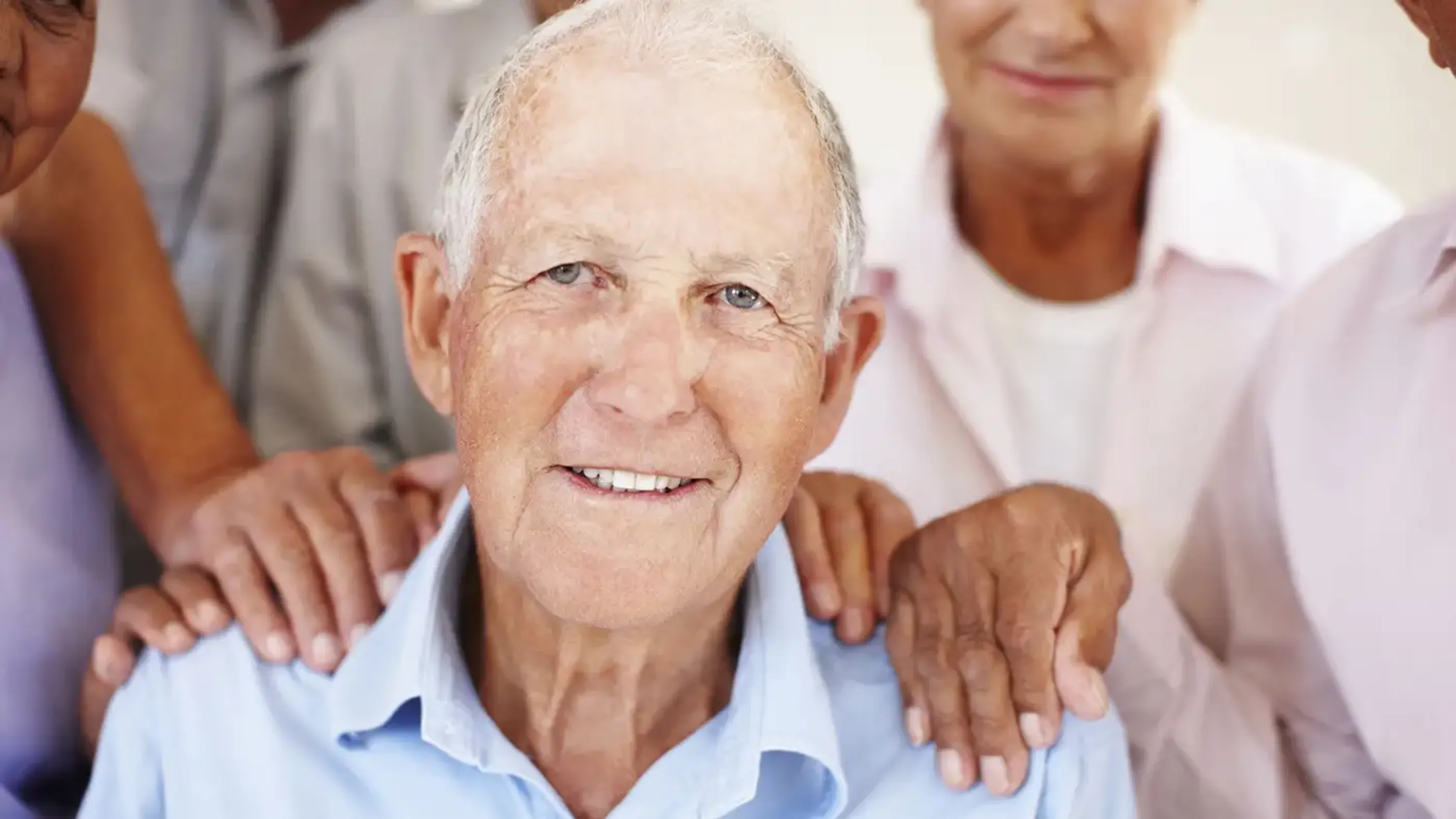 portrait d'un homme âgée avec des mains sur ces épaules