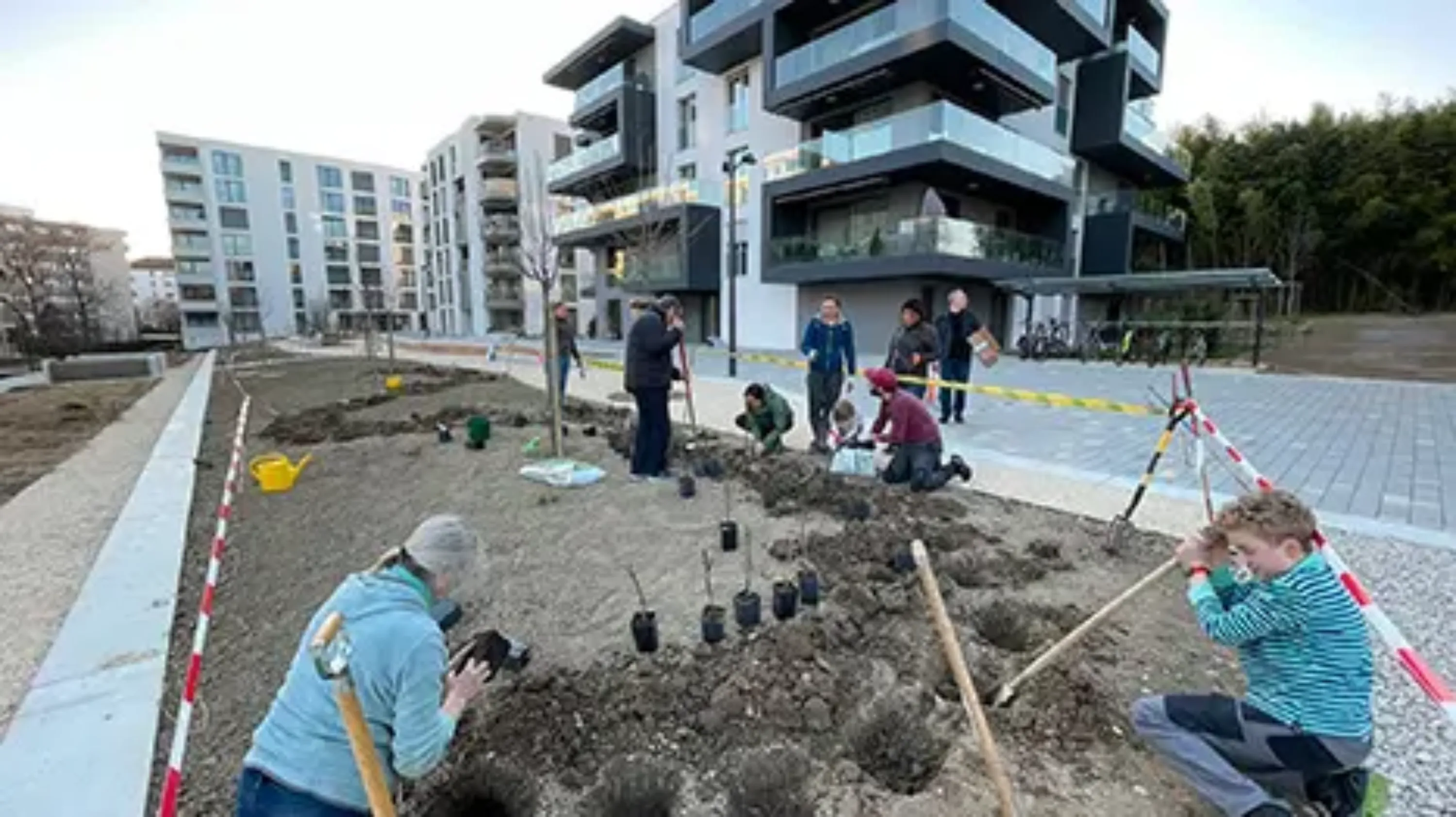 Des personnes plantent des arbustes et des fleurs dans le cadre d'un projet communautaire