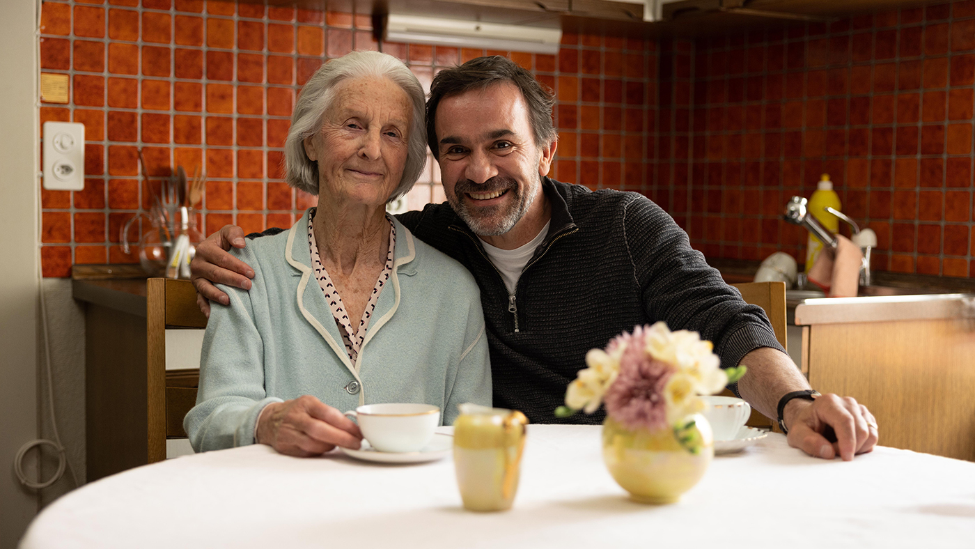 Seniorin mit ihrem Sohn beim Kaffee zu Hause