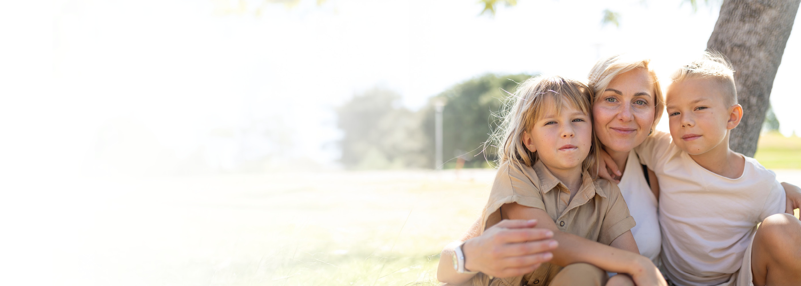 Une femme avec deux enfants regarde l'appareil photo